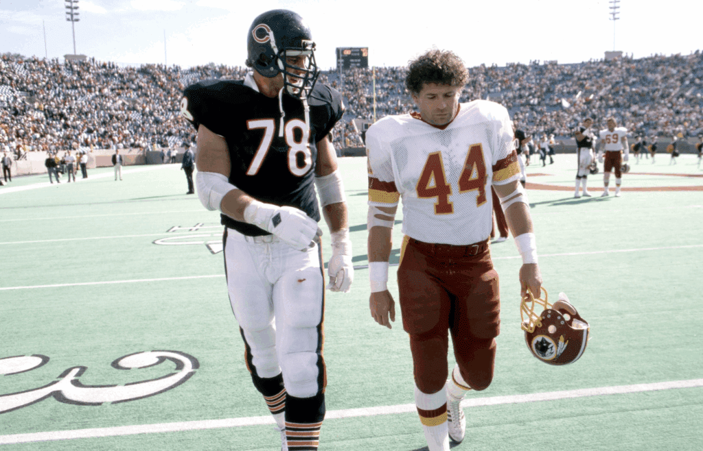 Sep 29, 1985; Chicago, IL, USA: FILE PHOTO; Chicago Bears tackle Keith Van Horne (78) talks to Washington Redskins running back John Riggins (44) as they leave the field following their game at Soldier Field. Mandatory Credit: Imagn Images