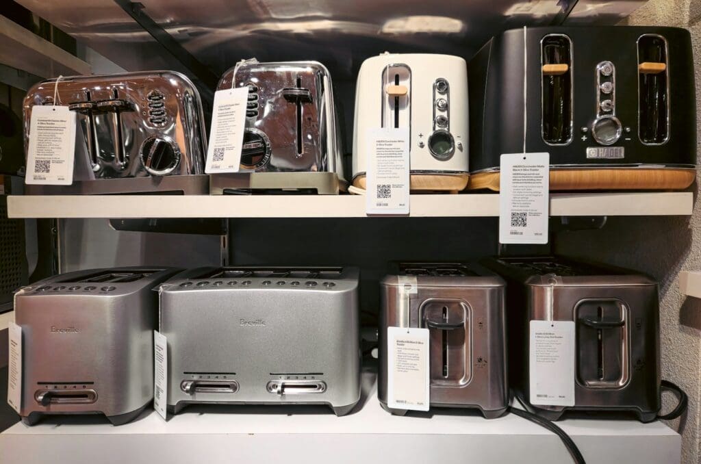 A bunch of toasters that are on a shelf