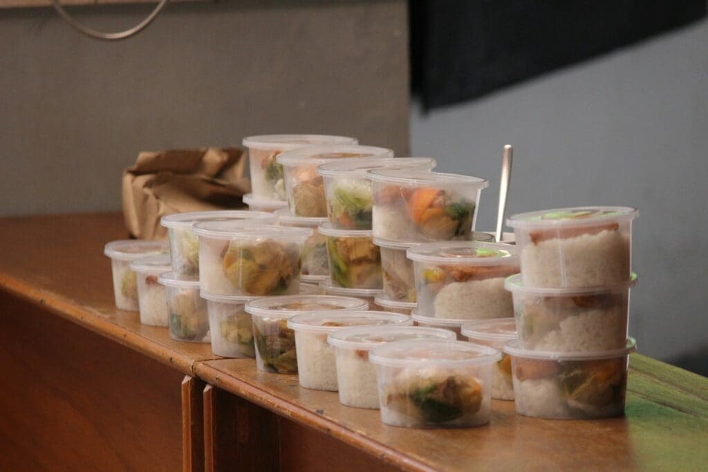 a table topped with plastic containers filled with food
